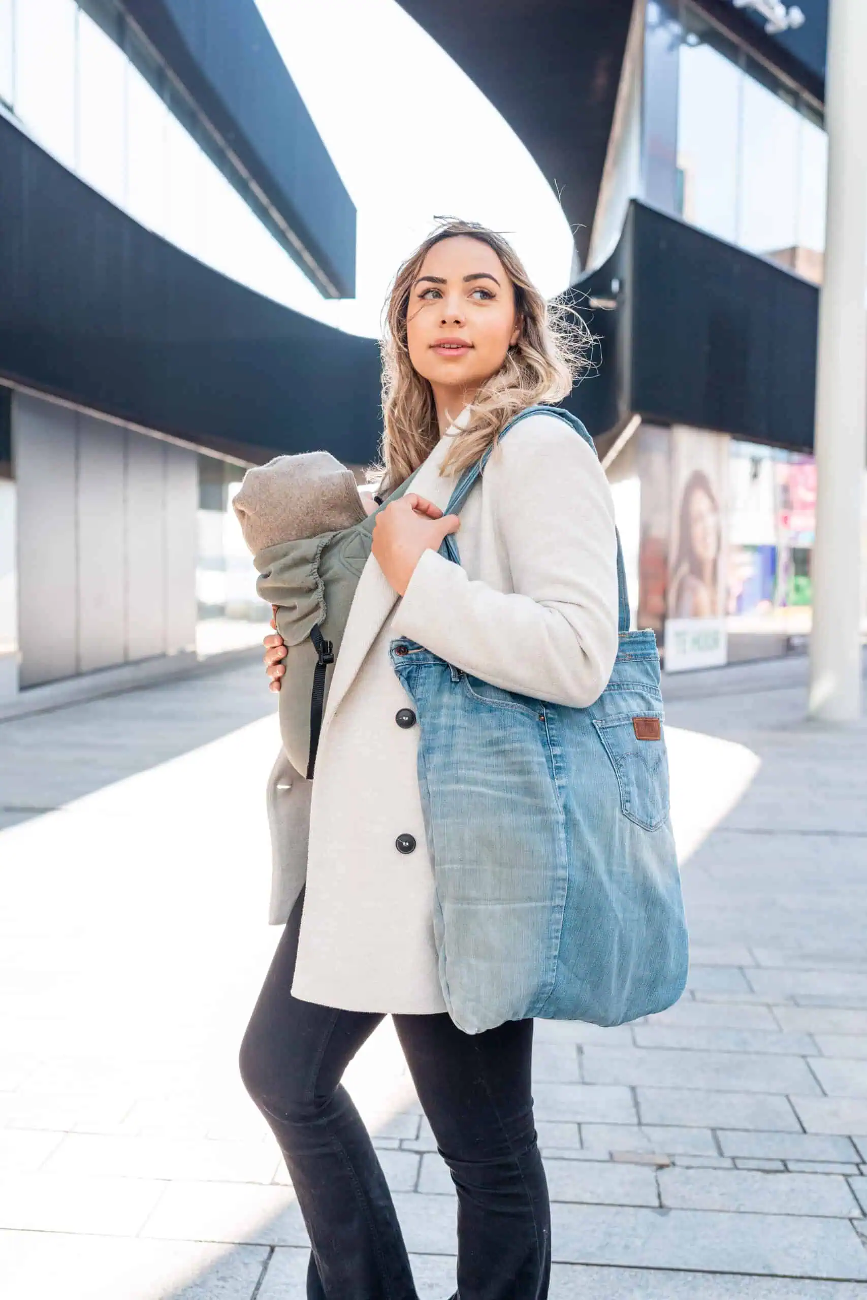 Parent carrying a baby with a blue denim tote bag